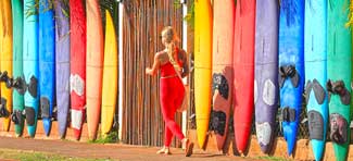 Maui woman walks by surfboards