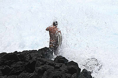 Hawaii Big Island surfer on rocks