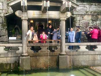 Visitors fill cups at The Pure Water Temple