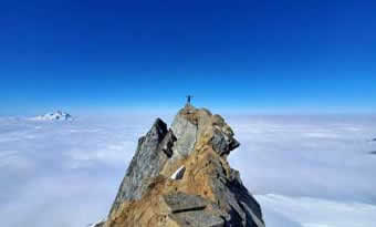 Jason Hardrath stands on summit of Sinister Peak