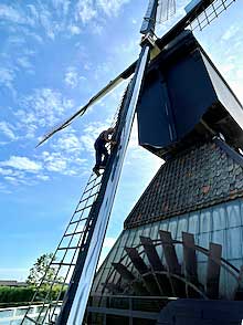 In Kinderdjik, a millwright climbs a sail