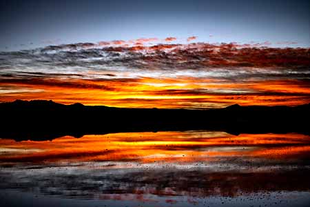 Bolivia, Orange sunrise with water mirage